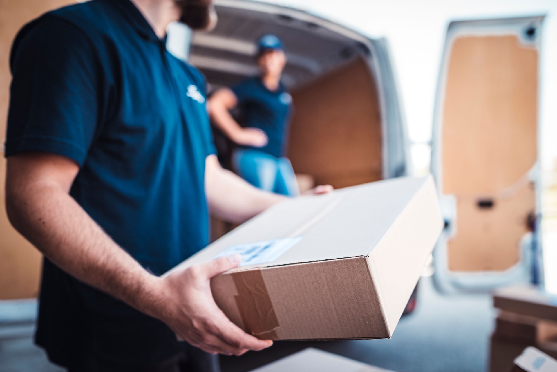 Coworkers rushing to load packages in a delivery van